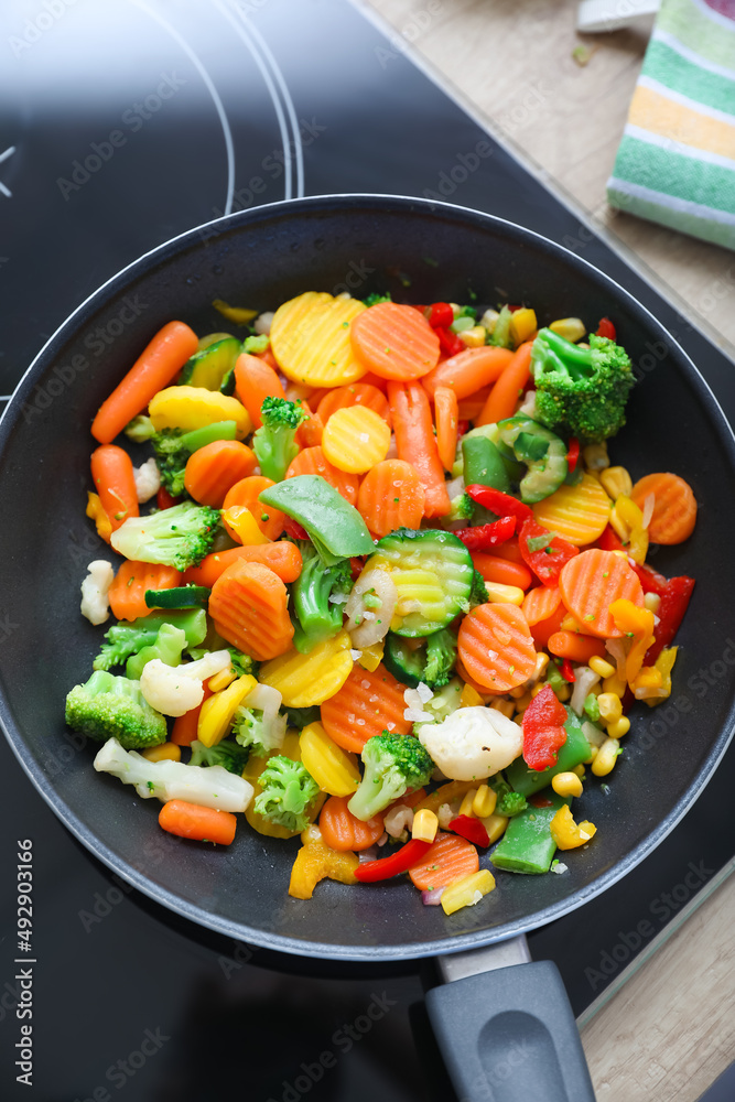 Frying pan with healthy vegetables on stove