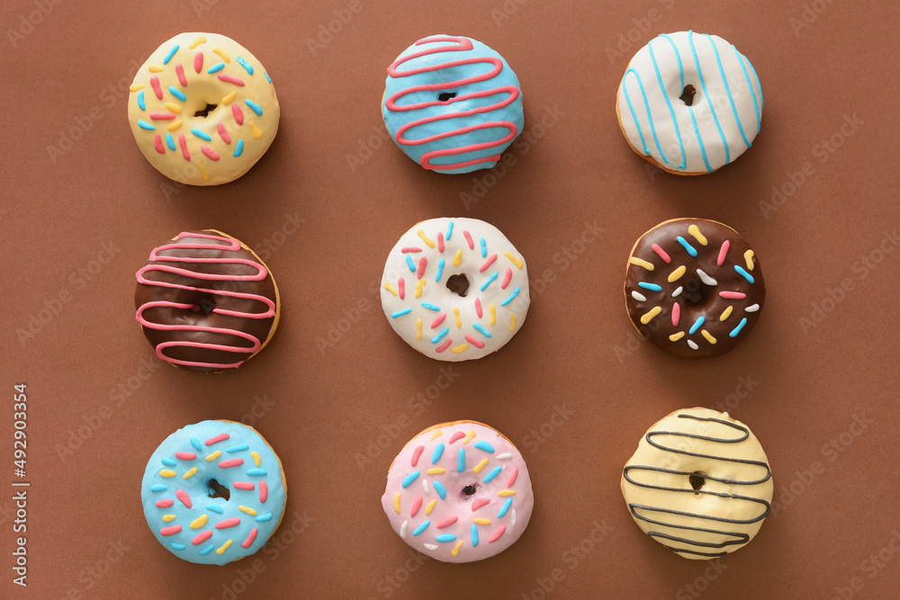 Different sweet donuts on brown background