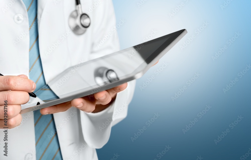 Beautiful young doctor, with a tablet for records. Medical student general practitioner. The concept