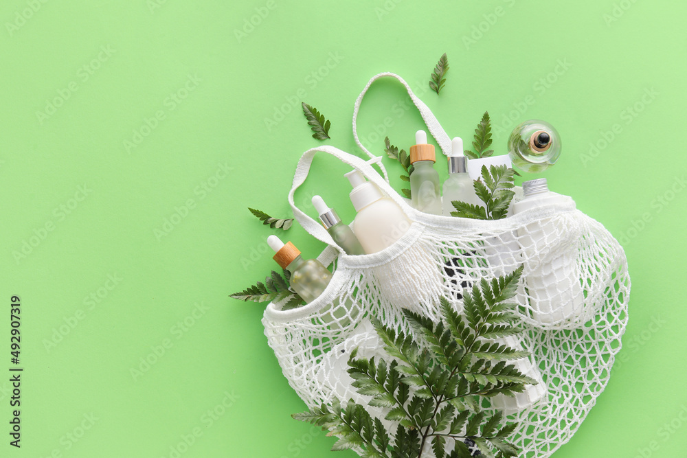 Shopping bag with natural cosmetics on color background