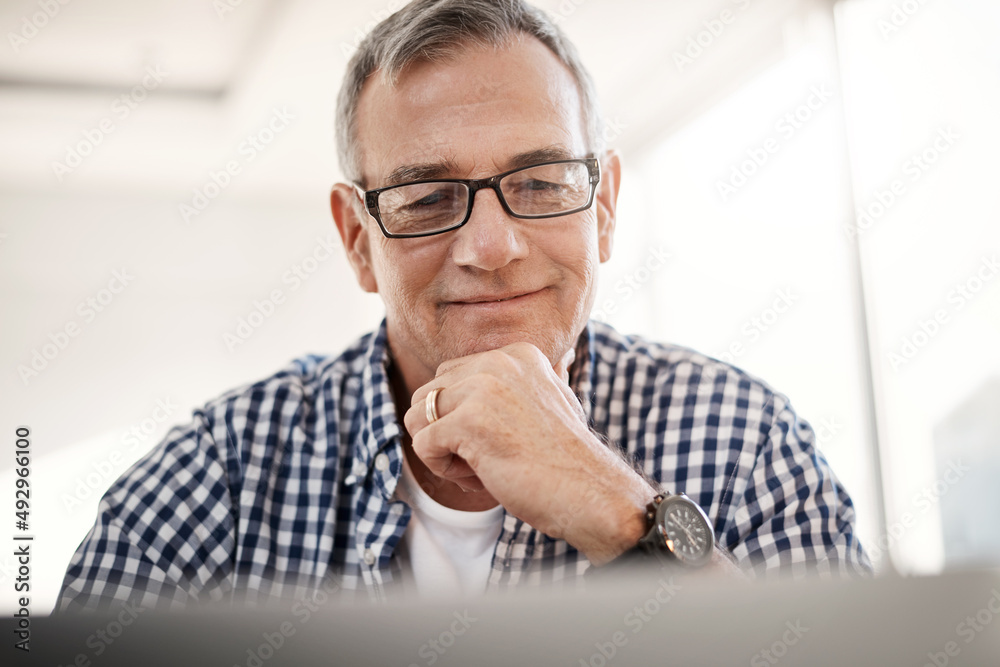 Theres so much to discover online. Shot of a mature man working on a laptop at home.