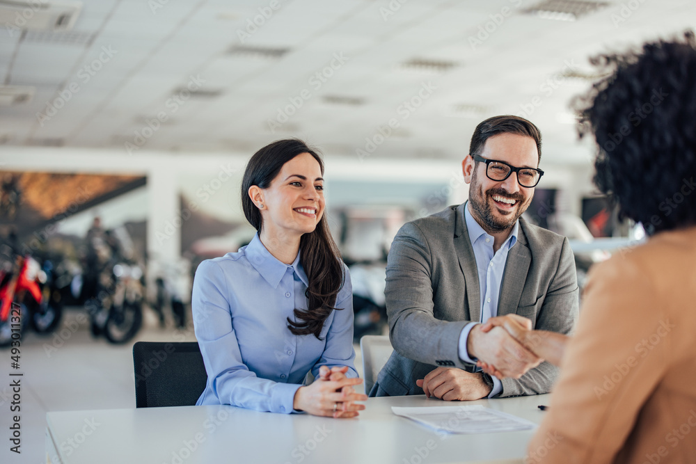 Delighted caucasian man and woman, handshaking with their compan