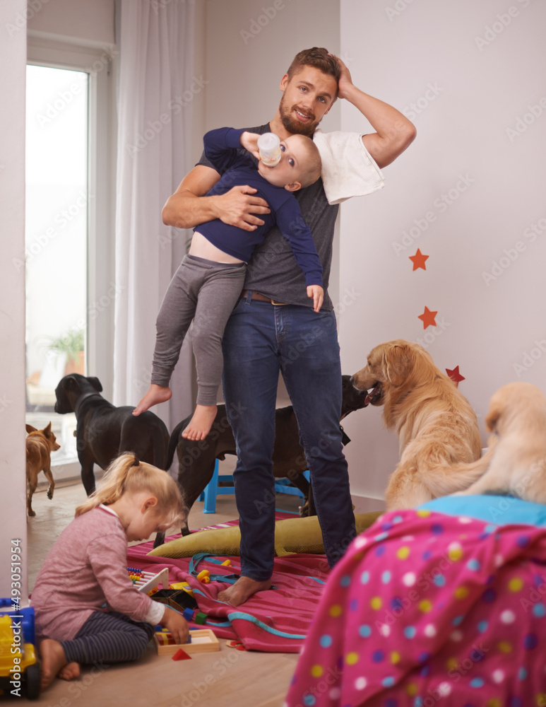 This is too much. An overwhelmed dad surrounded by his kids and dogs.