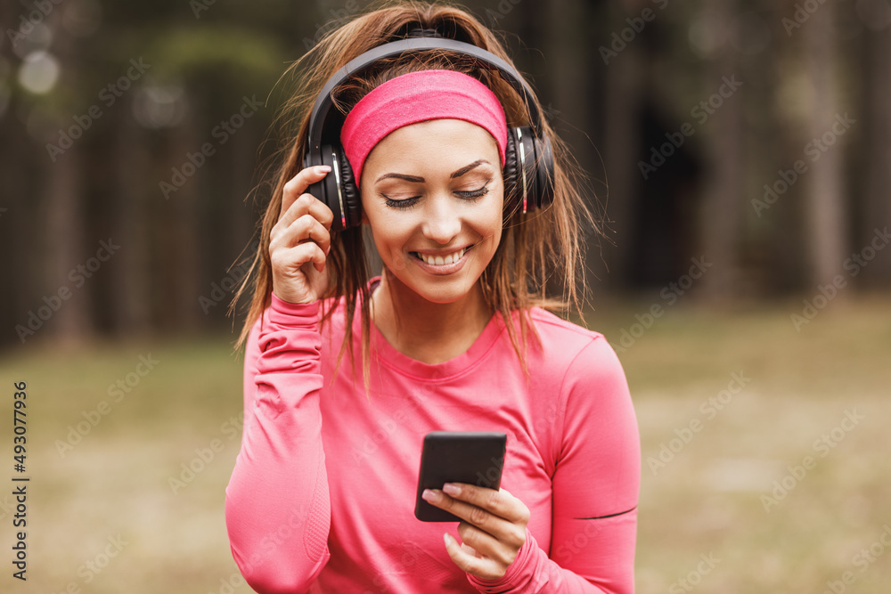 Woman Runner Is Listening To Music And Taking A Break After Jogging Outdoors