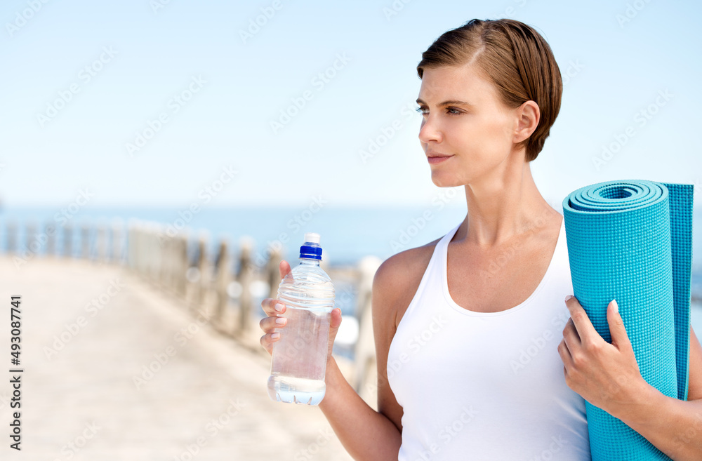 Time to get my fitness on. Shot of a beautiful pregnant woman getting ready for a workout at the sea