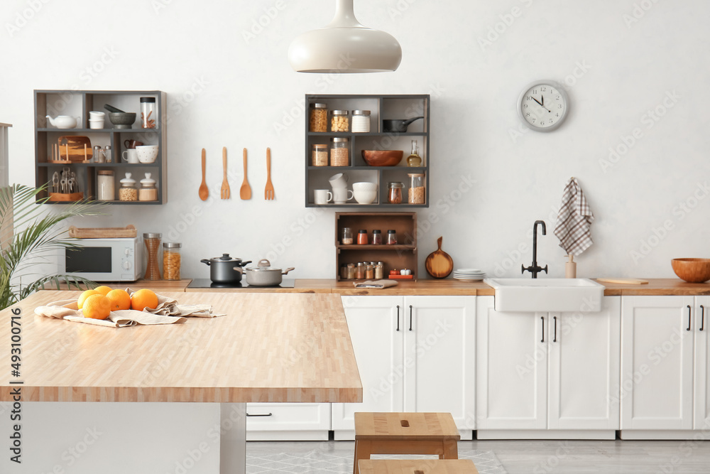 Interior of light modern kitchen with white counters and food