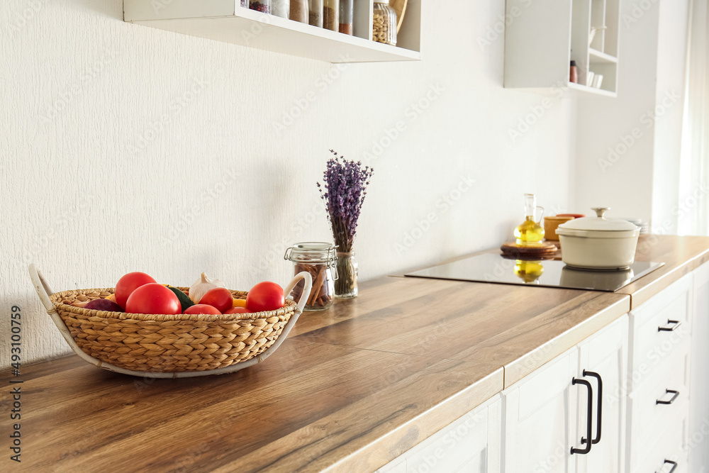 Wicker basket with food on table top near light wall