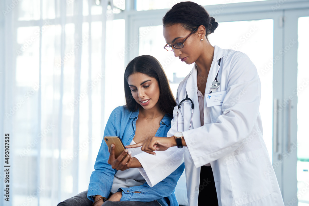 Ill send you some helpful health tips to you. Shot of a young doctor using a smartphone during a con