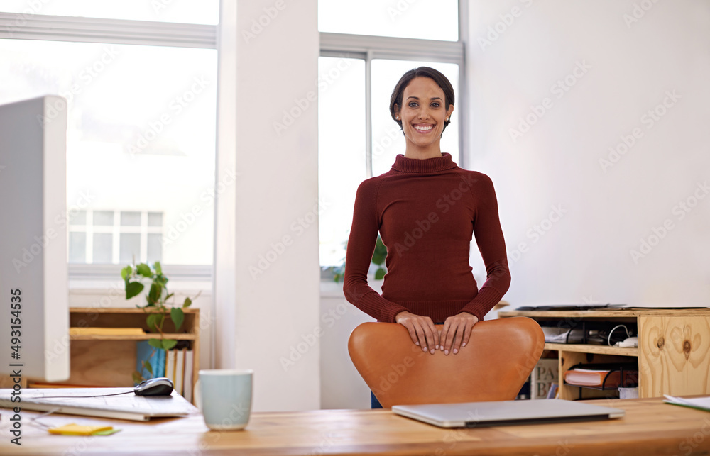 Welcome to my new office. A portrait of an happy young woman standing in her office.