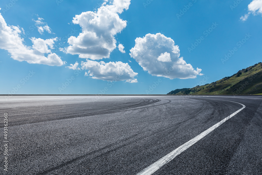 空旷的柏油路和蓝天下的山地自然风光。道路和山脉的背景。