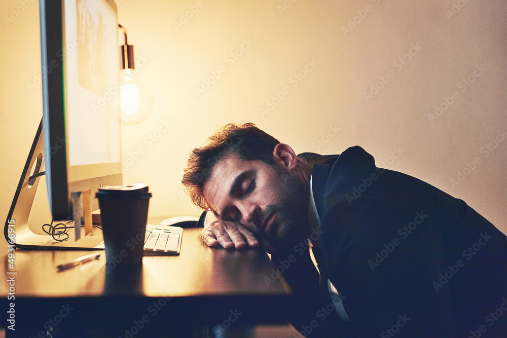 He just couldnt any longer. Cropped shot of a young businessman asleep at his desk during the late s