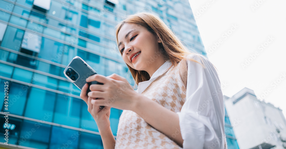 Young Asian woman using smartphone on street