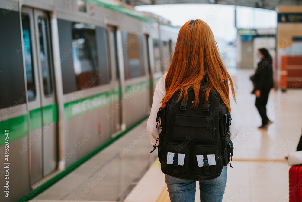 Young Asian girl waiting for the train at the station