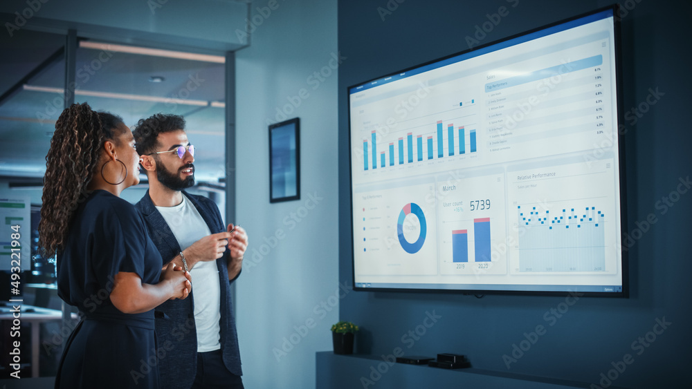 Company Operations Manager Holds Meeting Presentation. Black Female and Hispanic Male Uses TV Screen