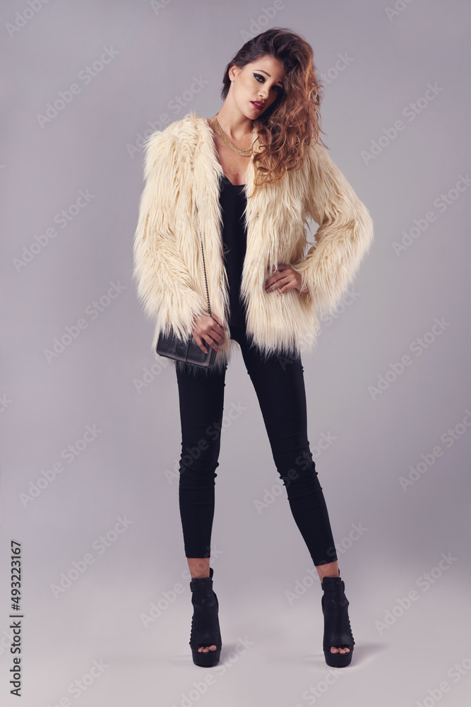 Strictly stylish. Studio portrait of a young woman posing against a grey background.