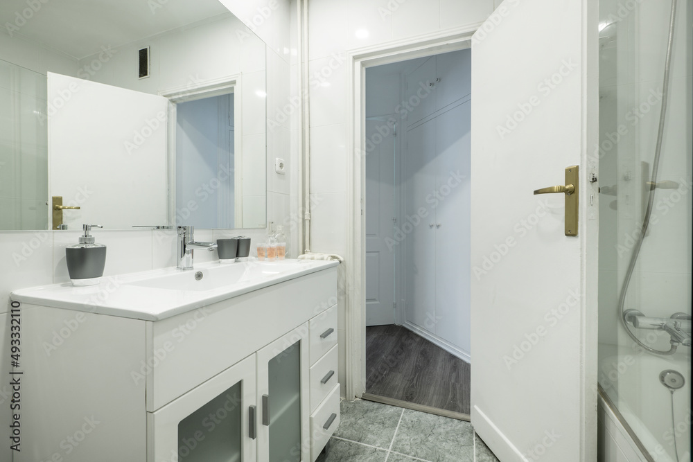 Bathroom with white resin vanity unit and sink, frameless rectangular mirror and walk-in shower with