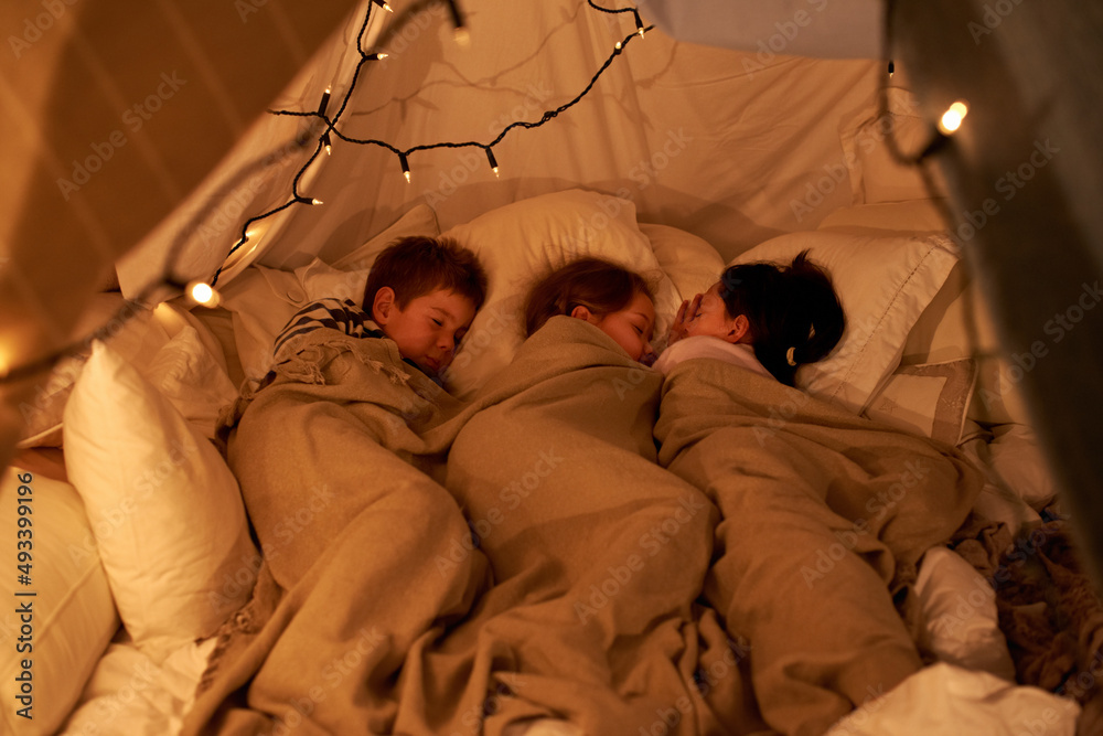 Sleeping little angels. Shot of three young children sleeping in blanket tent.