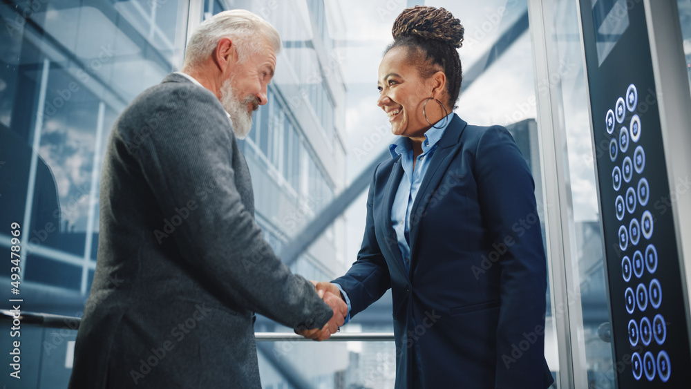 Middle Aged Businessman Talking with International Investment Partner while Riding Glass Elevator to