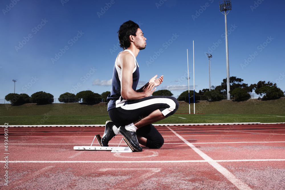 Clearing his mind before a race. A young athlete getting ready to start a race.