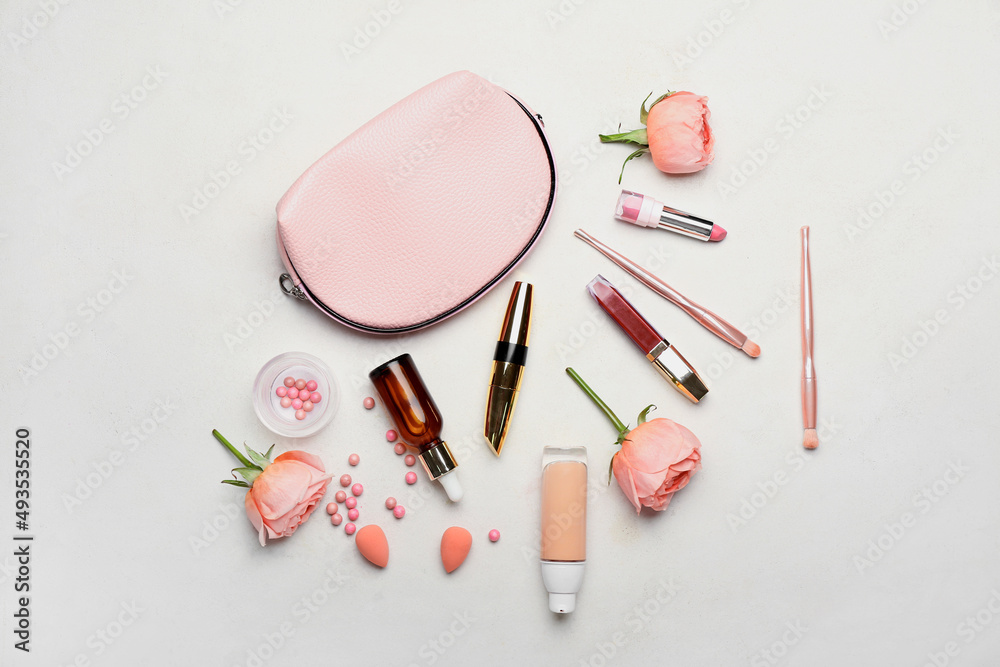 Composition with decorative cosmetics, bag and rose flowers on light background