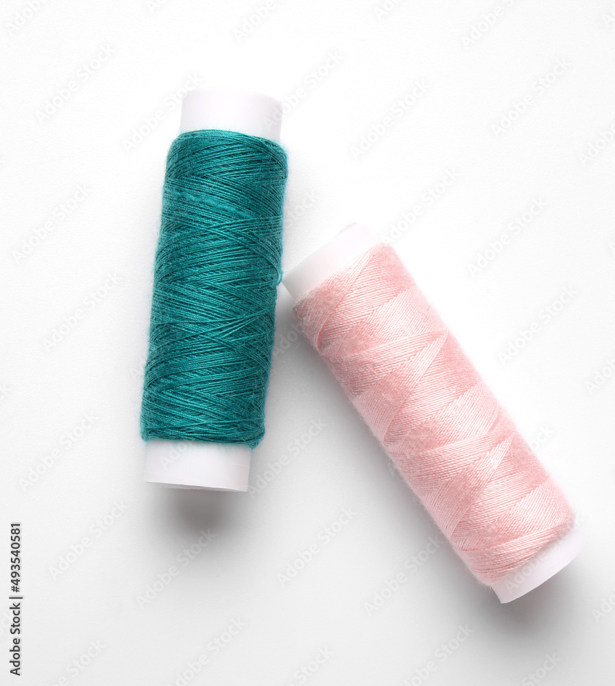 Different thread spools on white background