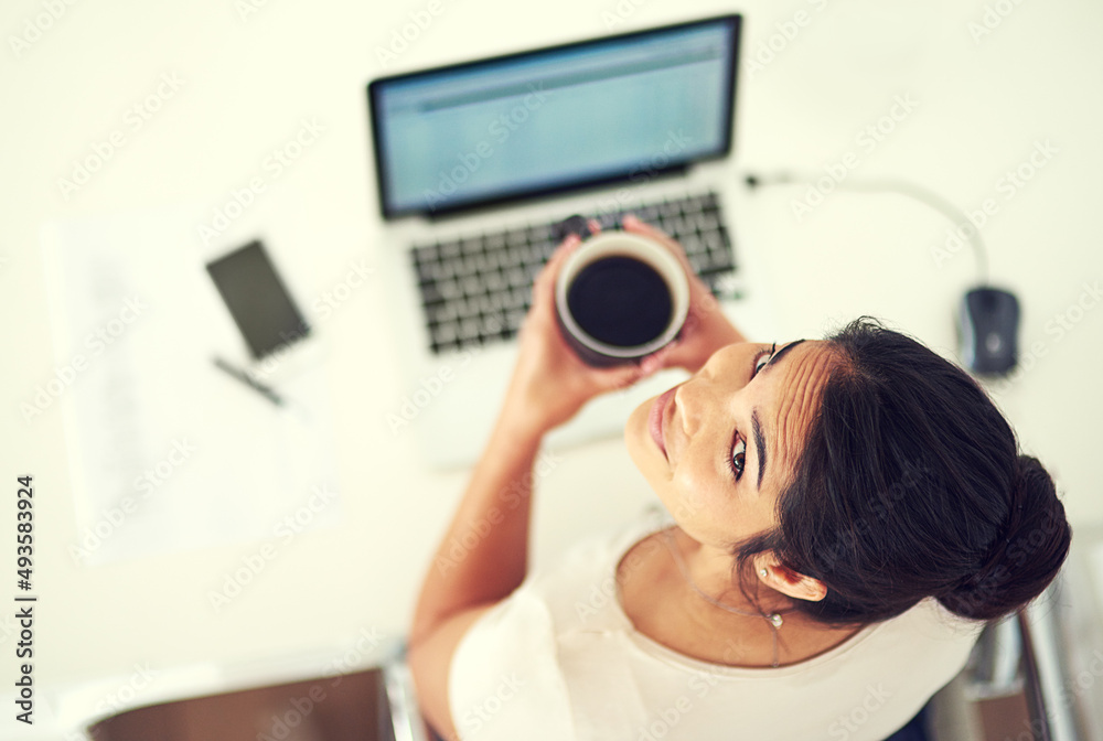 Im setting my sights on the top. High angle portrait of a young businesswoman drinking coffee while 