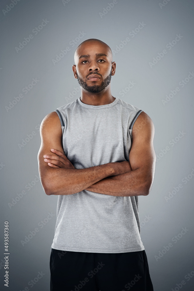 Fitness is a part of me. Shot of a sporty young man posing against a grey background.