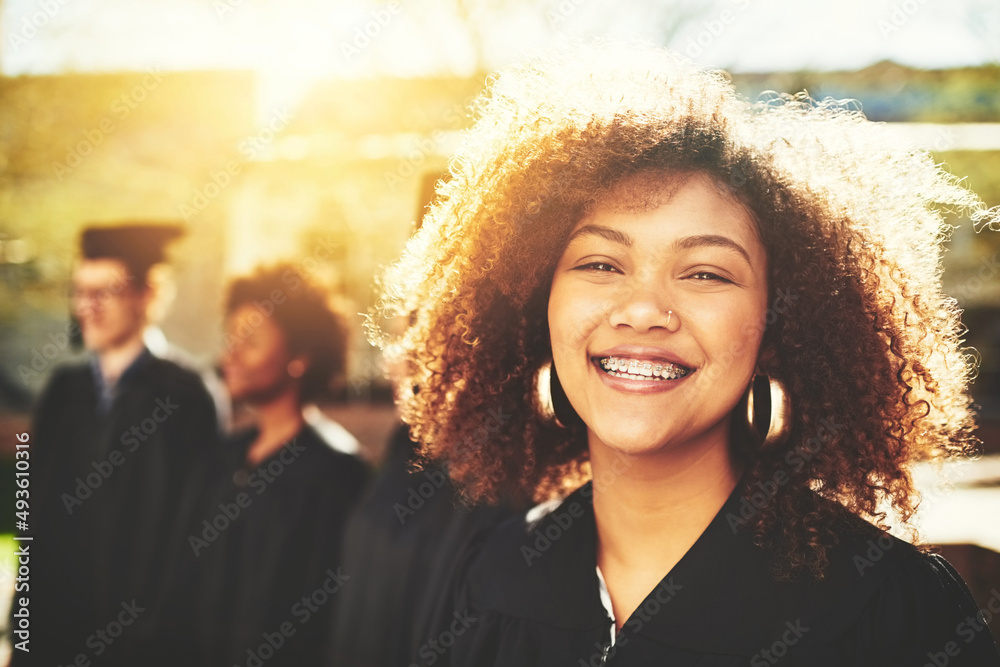 Im so happy to be graduating. Portrait of a smiling university student on graduation day with classm