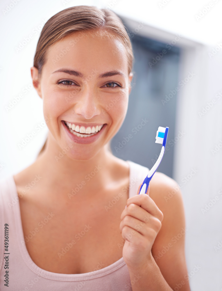 Taking care of her smile. A young woman brushing her teeth.