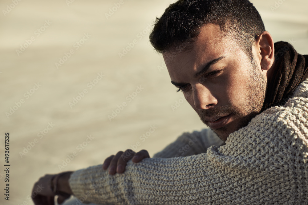 Getting away from it all. A ruggedly handsome young man enjoying the beach.