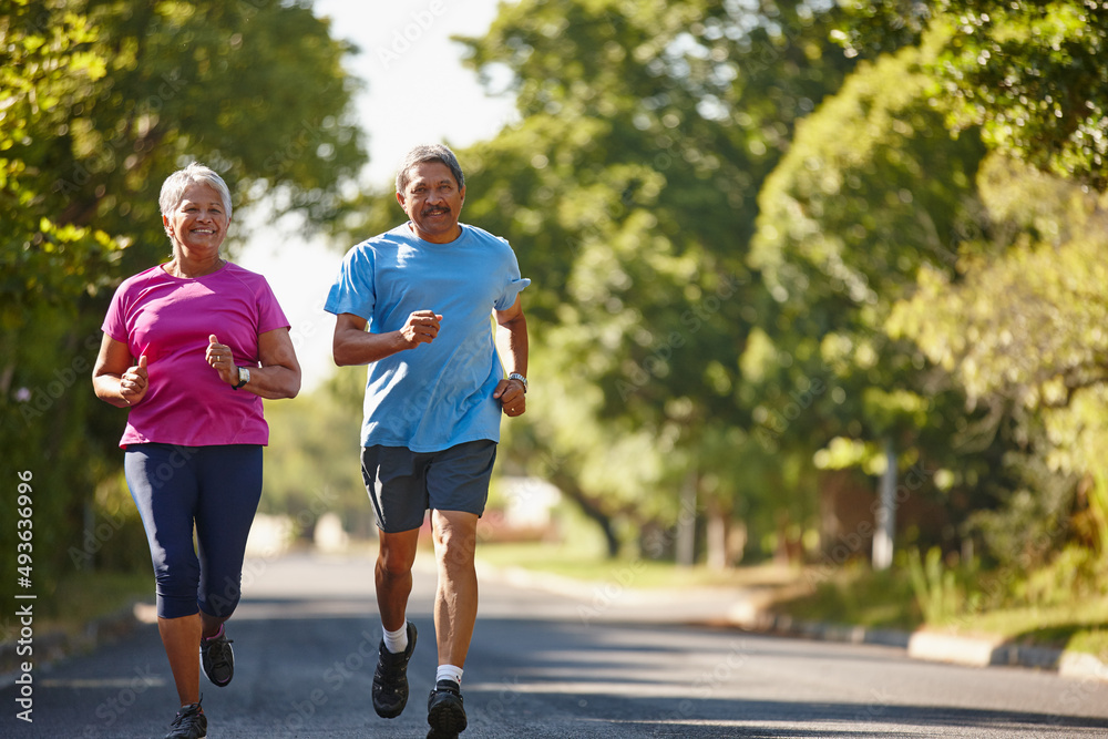 Happiness and healthiness is our goal. Shot of a mature couple jogging together on a sunny day.