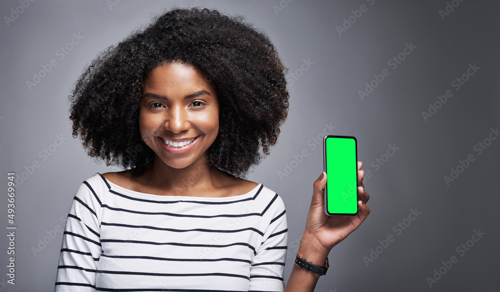 This app needs to be on your download list. Studio portrait of a young woman showing a smartphone wi