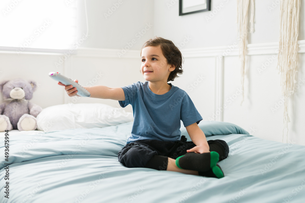 Cheerful elementary kid watching television