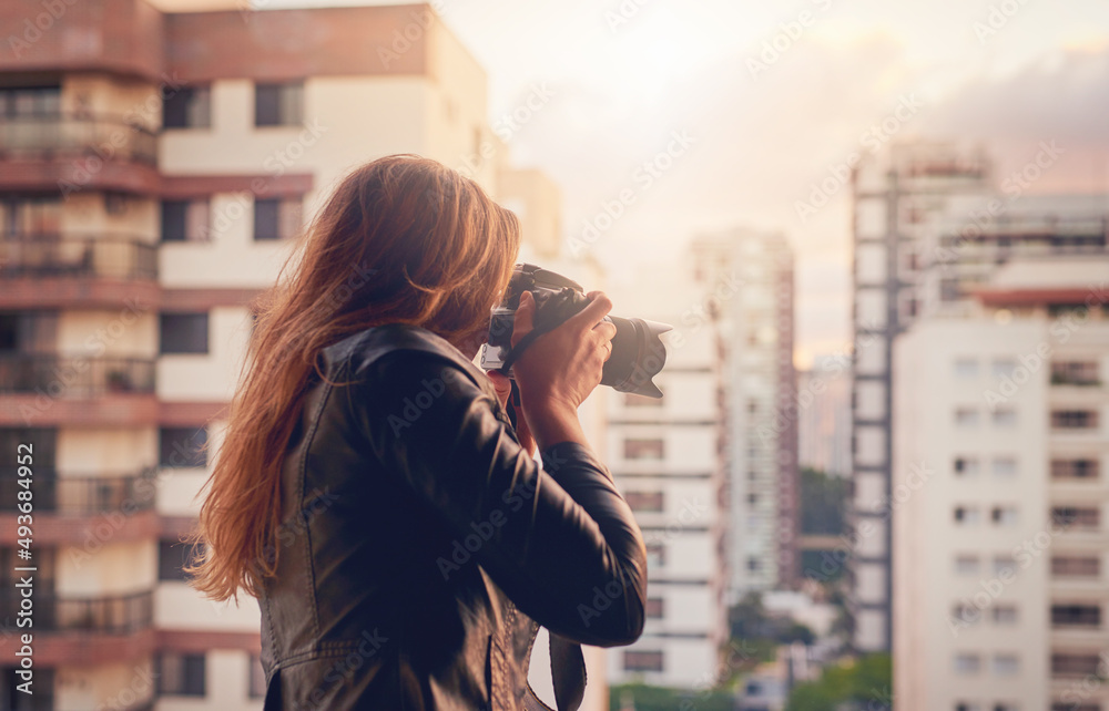 The city is mine to capture with my camera. Cropped shot of a young woman taking photographs of the 