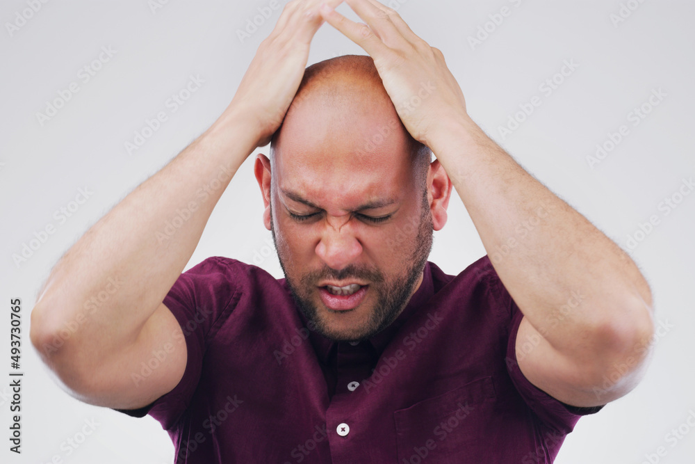 Its like a weight on his shoulders. Studio shot of a handsome young man looking stressed out against