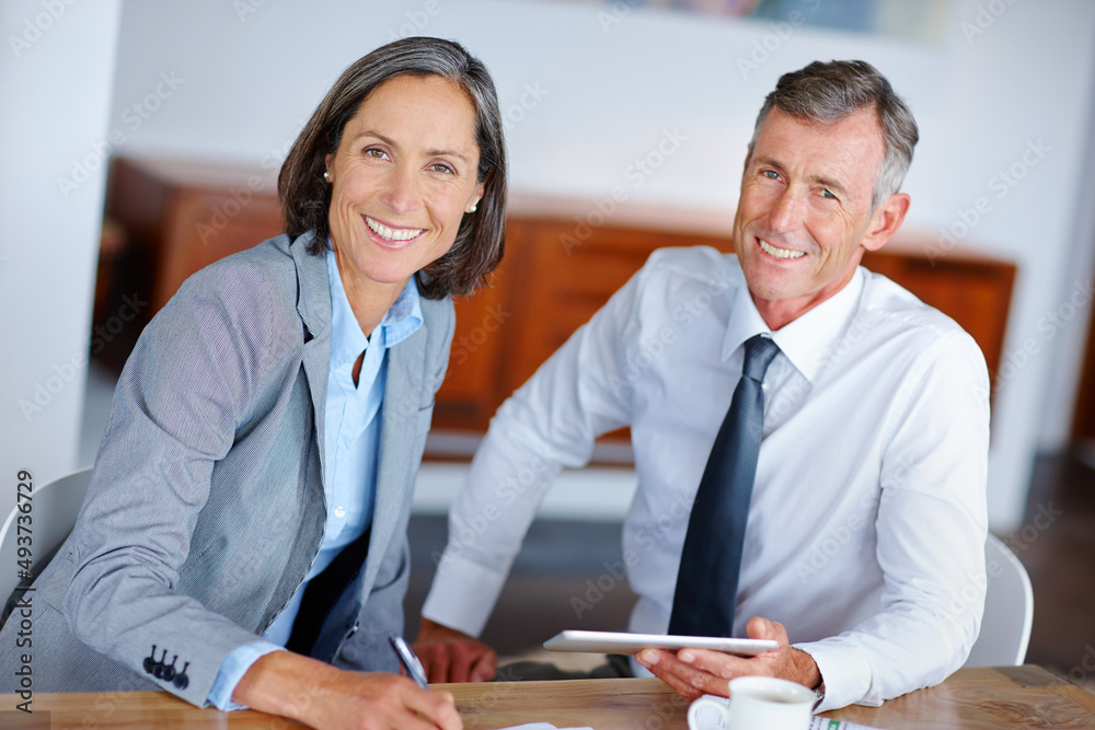 Theyre an experienced team. Shot of two mature business colleagues working together in the office.