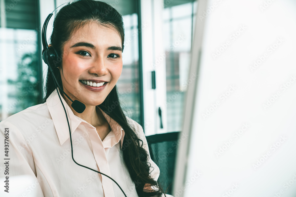 Businesswoman wearing headset working actively in office . Call center, telemarketing, customer supp