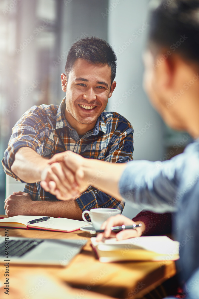 Making connections that count towards his success. Shot of two young designers shaking hands togethe