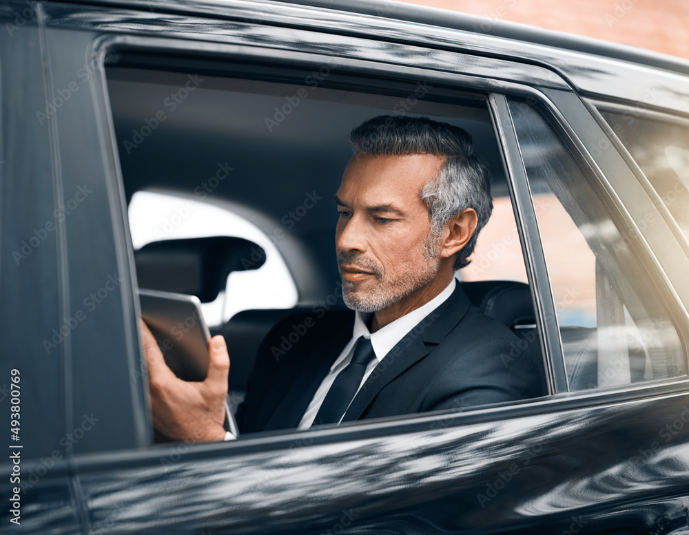 Staying connected is the key to success. Cropped shot of a handsome mature businessman using a table