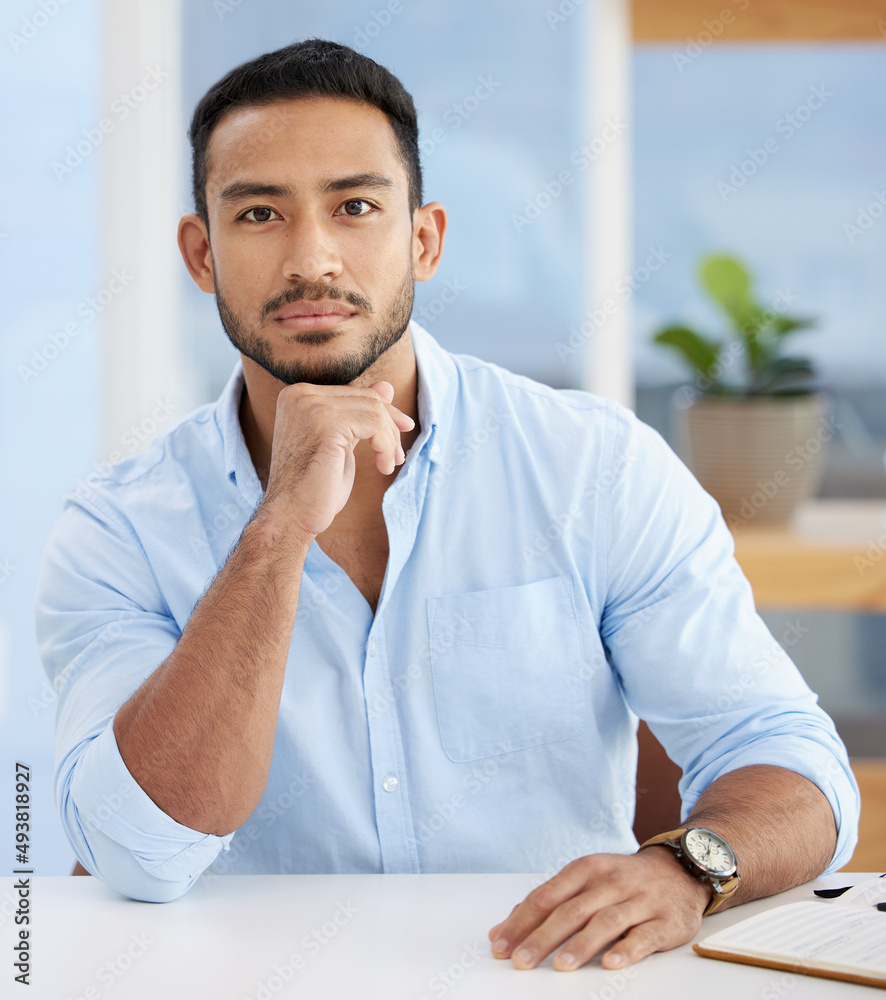 Put your business face on. Shot of a young businessman sitting at a desk at work.