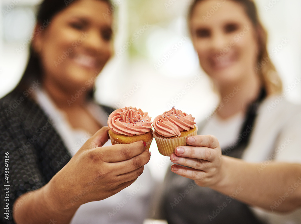 Well make you go cupcake crazy. Cropped shot of two bakers holding cupcakes.