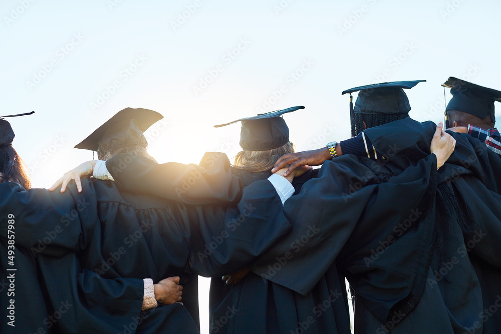 This is just the beginning. Rearview shot of a group of students standing in a row on graduation day