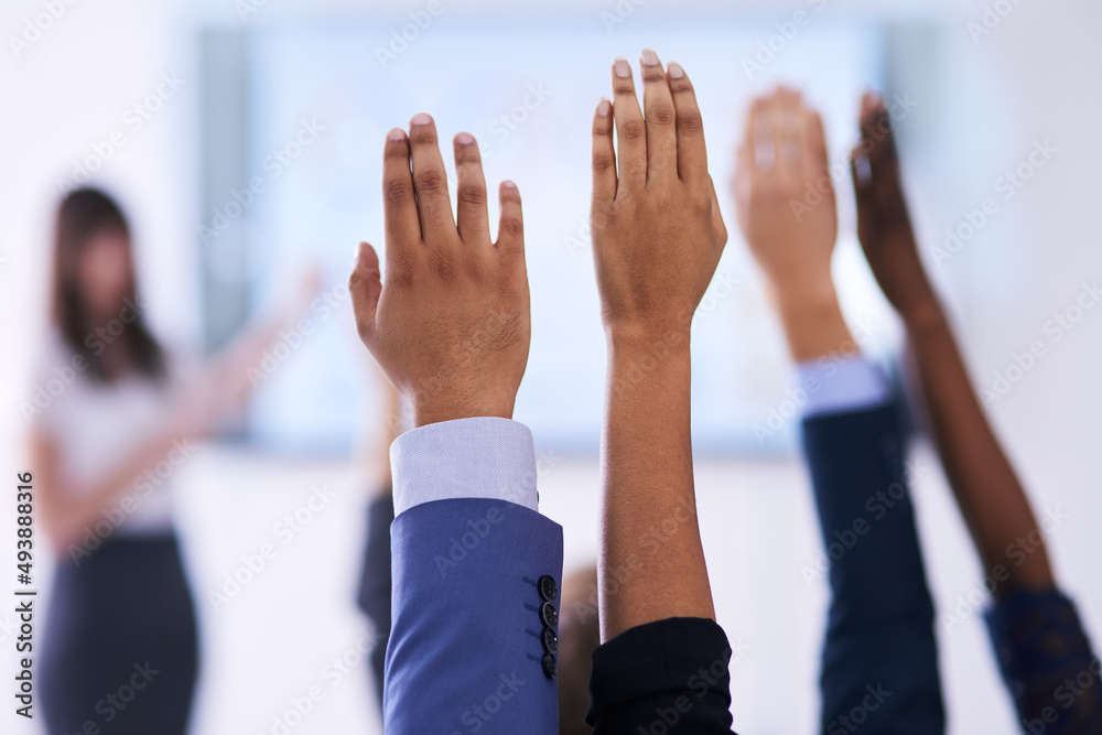 They have all the answers. Shot of a group of people raising their hands in a class.