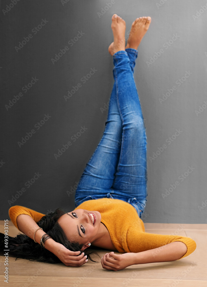 Going for the laid back look. Studio shot of an attractive young woman posing against a gray backgro