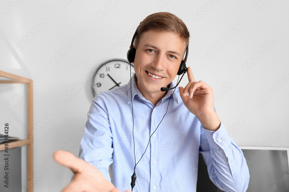 Answering consultant of call center with headset working in office