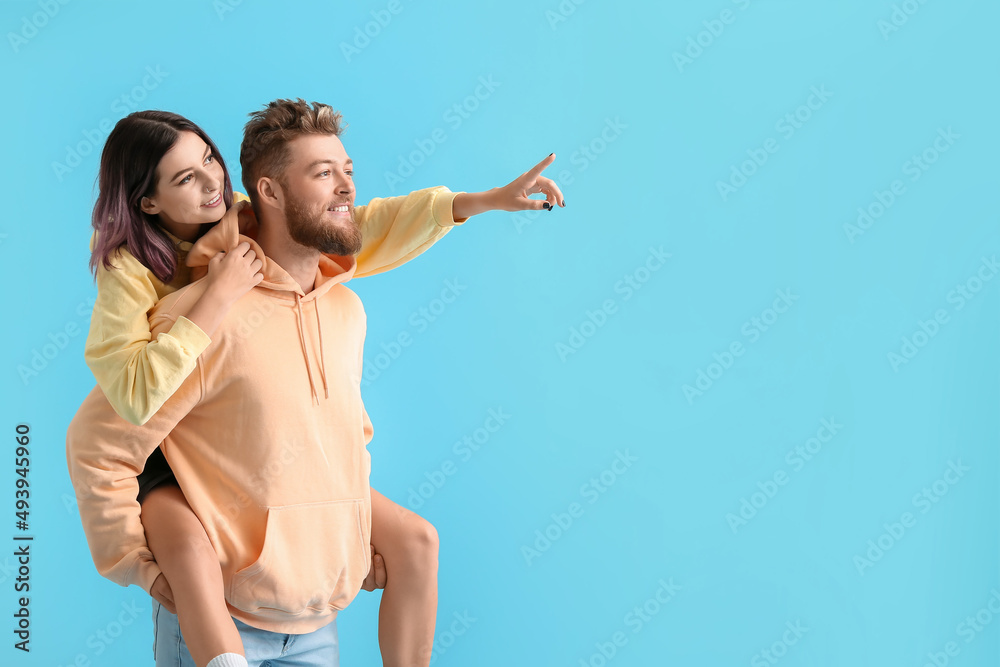 Cool young couple in hoodies on color background