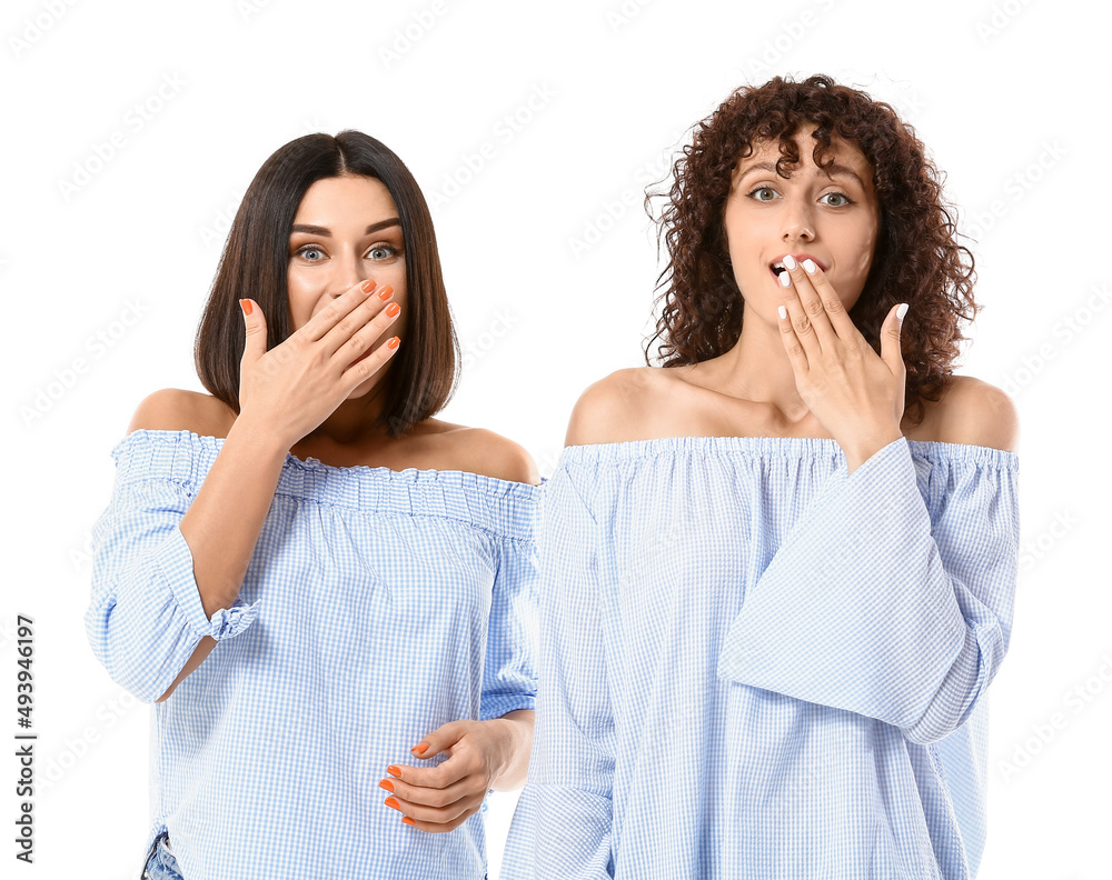 Surprised sisters on white background