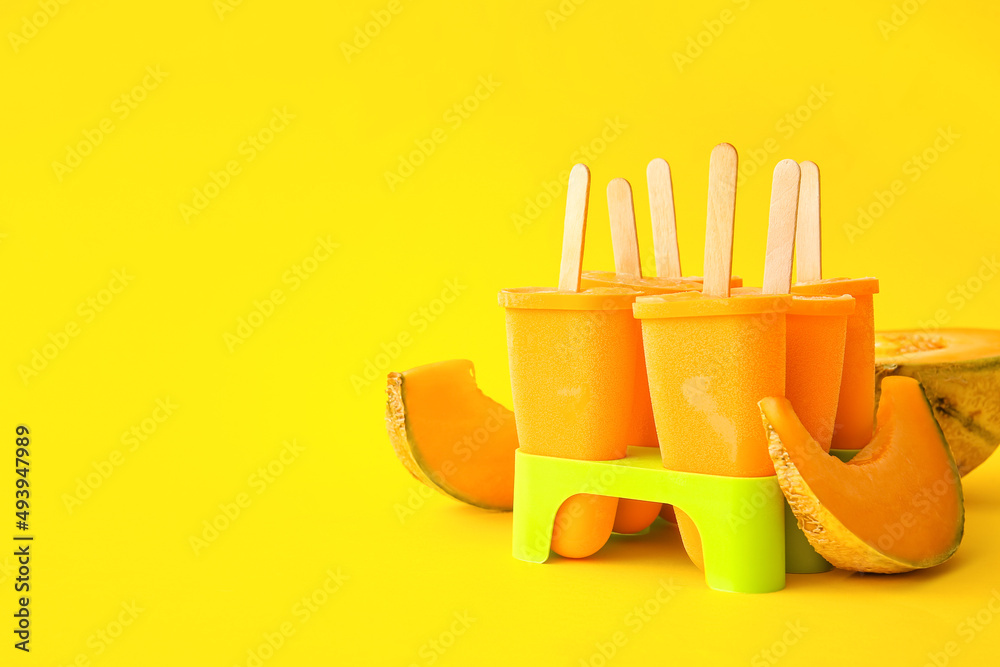 Containers with tasty popsicles and melon on yellow background