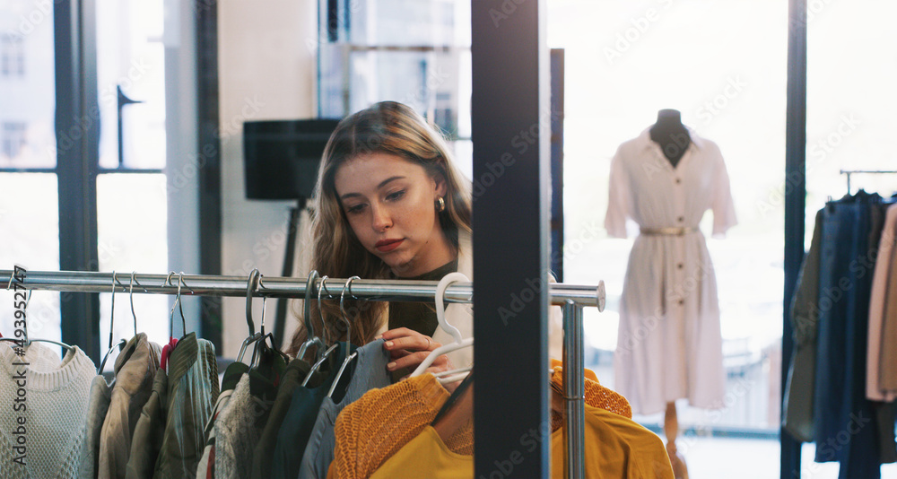 只是浏览。一张年轻女子在精品店浏览衣服的照片。