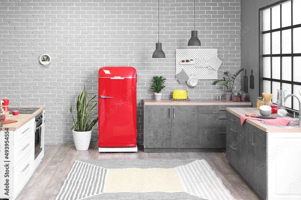 Interior of modern kitchen with counters and stylish refrigerator